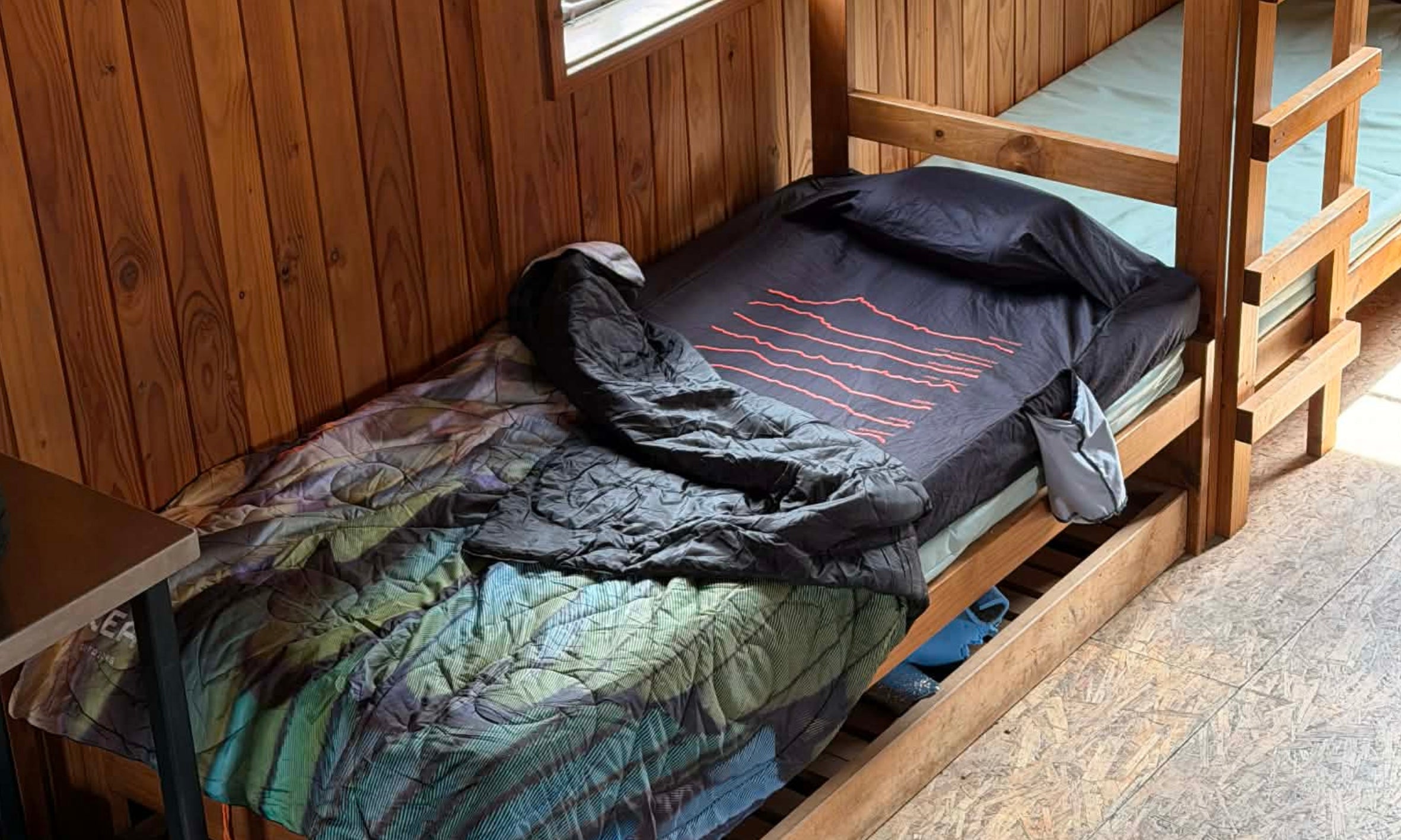 Tramper preparing a sleeping system inside a New Zealand backcountry hut